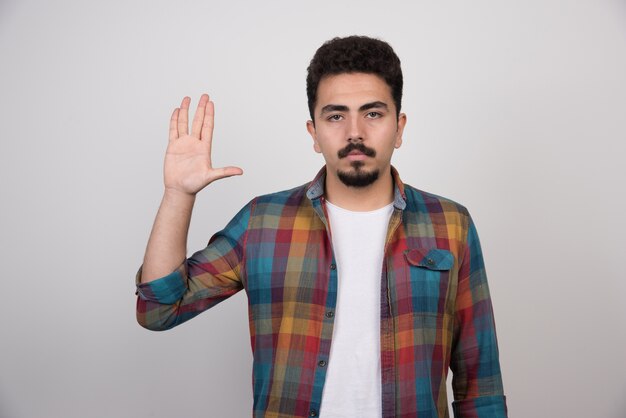 Young handsome man with beard making stop gesture.