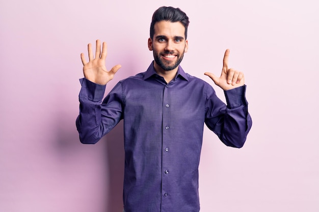 Free Photo young handsome man with beard wearing casual shirt showing and pointing up with fingers number seven while smiling confident and happy.