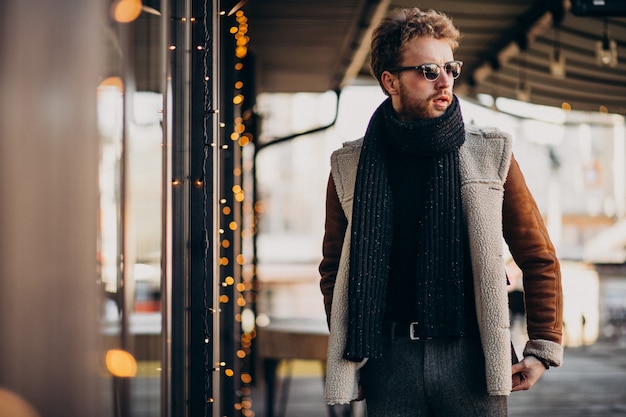 Young handsome man with winter clothes walking on street