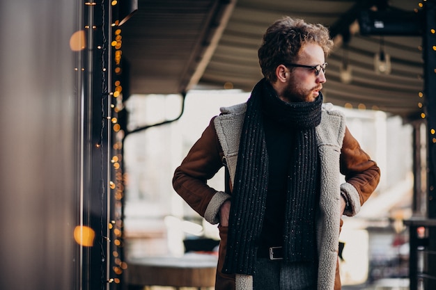 Free photo young handsome man with winter clothes walking on street