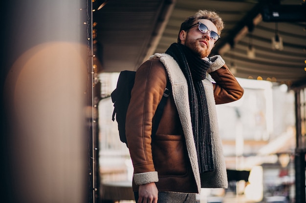 Free photo young handsome man with winter clothes walking on street