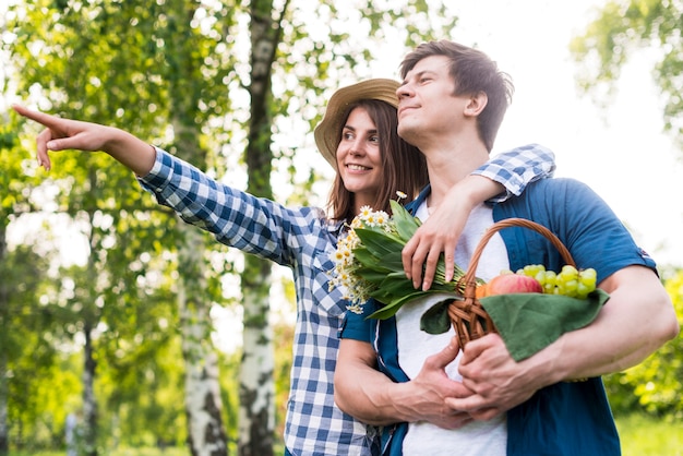 Free photo young happy couple choosing picnic place in nature