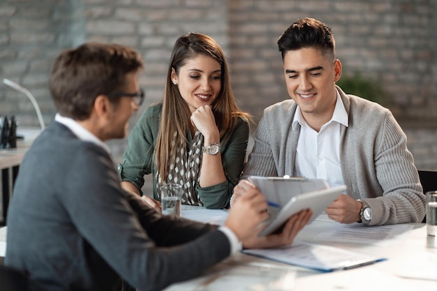 Young happy couple having consultations with bank manager on a meeting in the office