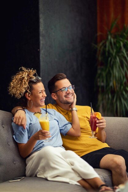 Young happy couple with fruit cocktails enjoying in their time together