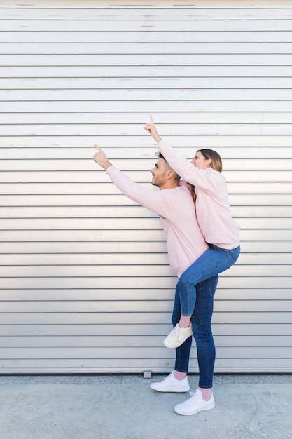 Free photo young happy man holding attractive woman with upping hands