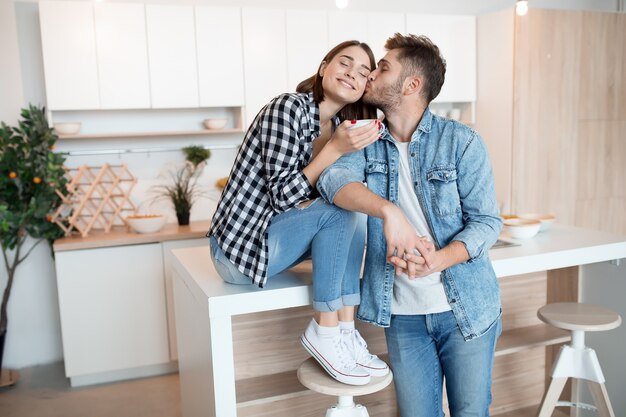 Young happy man and woman in kitchen, breakfast, couple together in morning, smiling, having tea