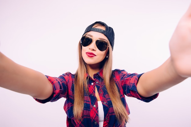 Young happy smile girl take selfie on white wall