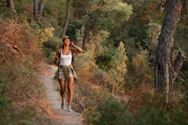 Free Photo young happy woman hiking in the mountains while using her mobile phone