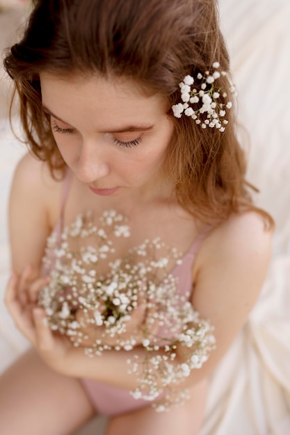 Young happy woman posing with flowers