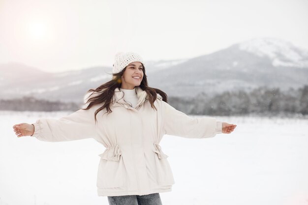 young happy woman in winter jacket in snow outdoor