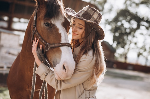 Young happy woman with horse at ranch