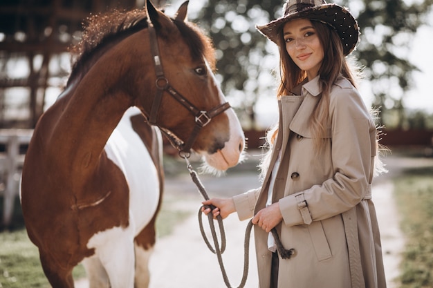 Young happy woman with horse at ranch