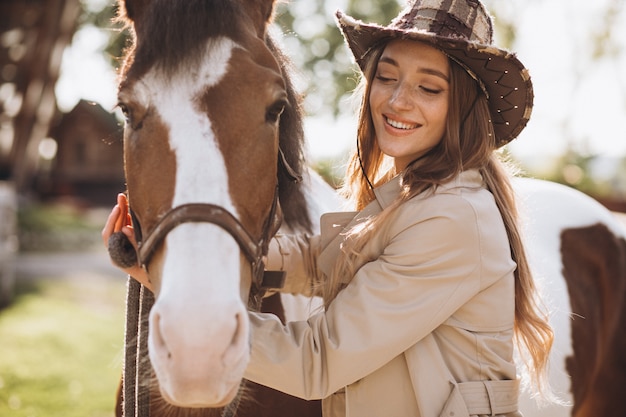 Young happy woman with horse at ranch