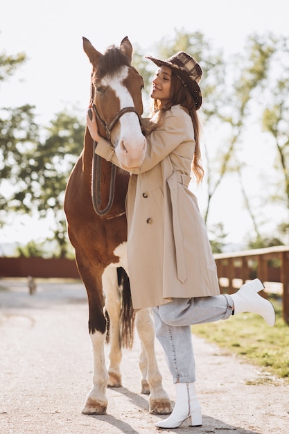 Young happy woman with horse at ranch