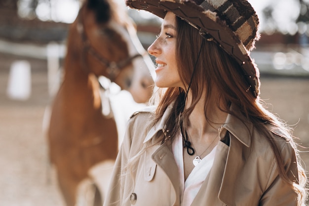 Young happy woman with horse at ranch