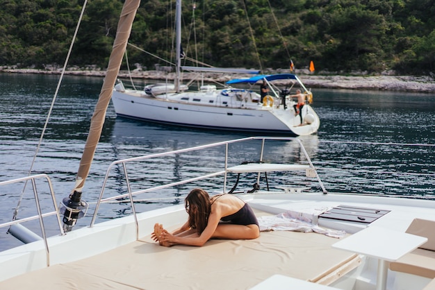 Free Photo young healthy and calm woman doing yoga on sailing yacht boat in sea at island 