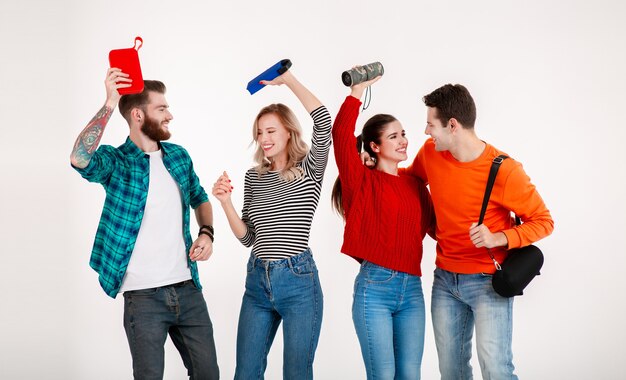 Young hipster company of friends having fun together smiling listening to music on wireless speakers