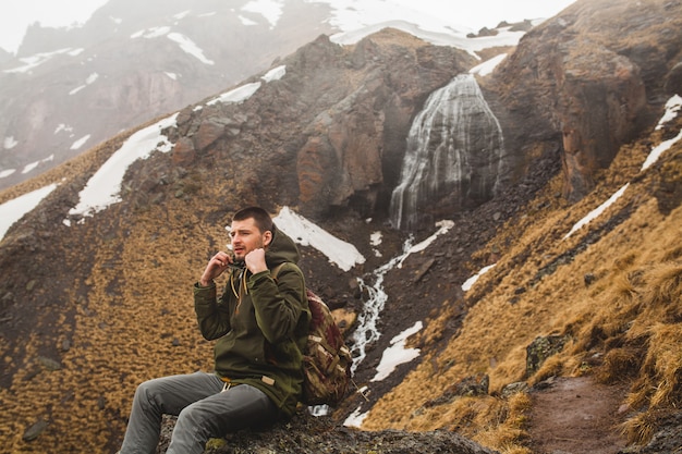 Young hipster man hiking in mountains, autumn vacation traveling