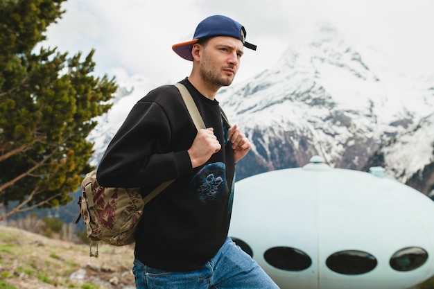 Young hipster man sitting in mountains