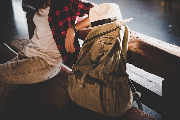 Free Photo young hipster tourist woman with backpack sitting in the train station. holiday tourist concept.