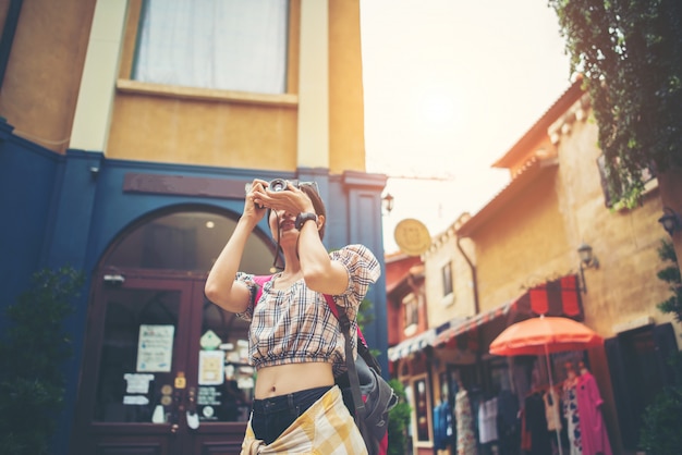 Young hipster woman enjoy taking photo in urban while traveling.