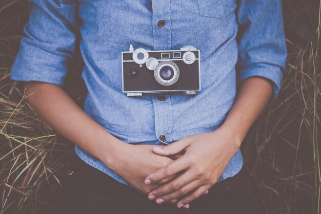 Free Photo young hipster woman lying down on summer field after shooting photo.