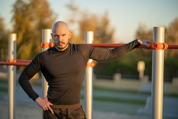 Young Hispanic man having a rest after working out in the sports ground