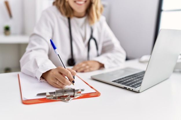 Free photo young hispanic woman wearing doctor stethoscope working at clinic