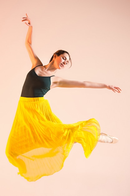 Young and incredibly beautiful ballerina is dancing at studio