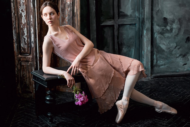 Free photo young and incredibly beautiful ballerina is posing in a black studio