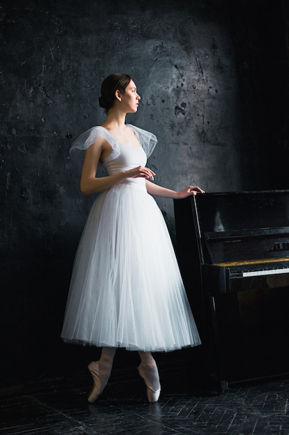 Free Photo young and incredibly beautiful ballerina is posing in a black studio