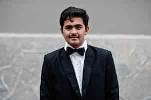 Free photo young indian man on black suit and bow tie posed outdoor