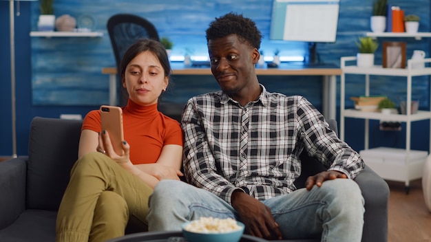 Young interracial couple talking on video call with camera