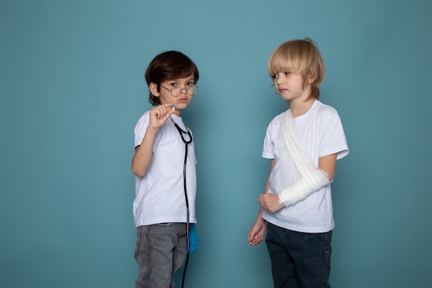 Young kids cute sweet adorable in white t-shirts and jeans on blue desk