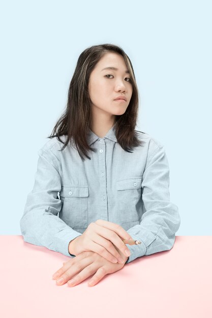 Young korean women smoking cigar while sitting at table at studio.