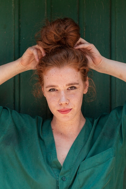 Free photo young lady arranging her red hair