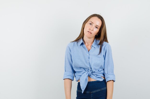 Young lady in blue shirt, pants standing by force and looking exhausted