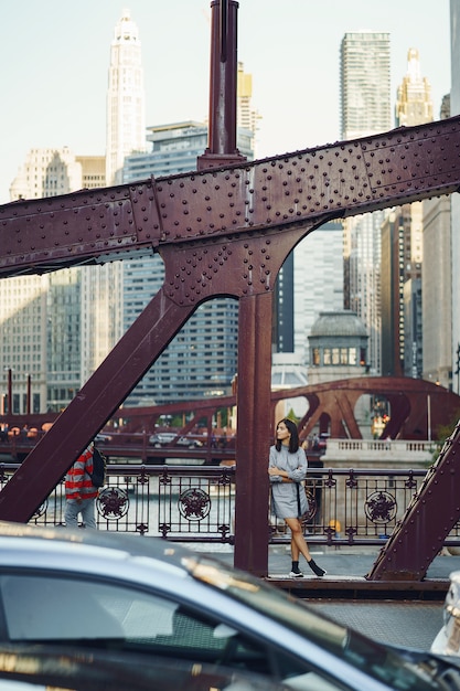 Free photo young lady crossing the bridge in the city