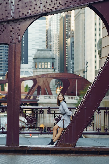 Free Photo young lady crossing the bridge in the city