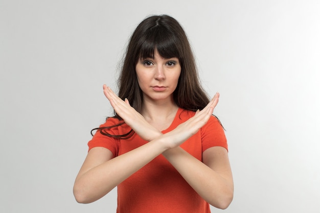 Free Photo young lady in designed t-shirt showing no way sign with long hair on white