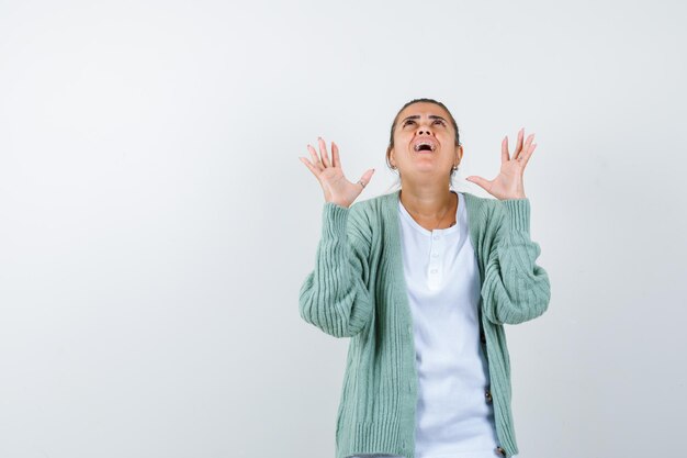 Young lady keeping hands in aggressive manner in t-shirt, jacket and looking annoyed