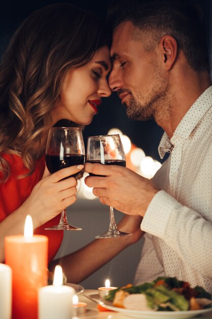 Young lady kiss her gorgeous man while have romantic dinner