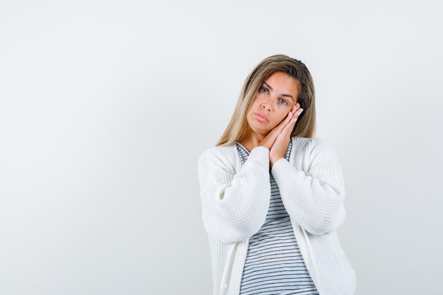 Young lady leaning on palms as pillow in t-shirt, jacket and looking cute , front view.