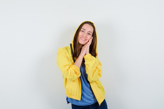 Young lady leaning on palms as pillow in t-shirt, jacket and looking cute