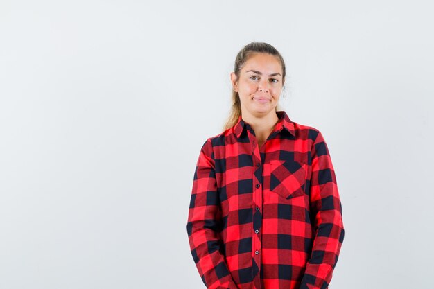 Young lady looking at camera in casual shirt and looking cheerful , front view.