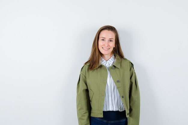 Young lady looking at camera in shirt, jacket and looking captivating, front view.