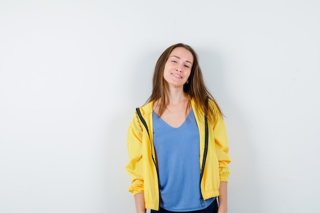 Free photo young lady looking at camera in t-shirt, jacket and looking confident, front view.