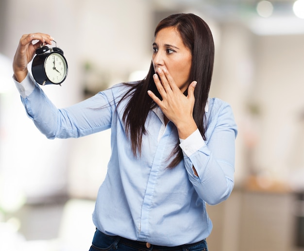 Young lady looking at the time and covering her mouth