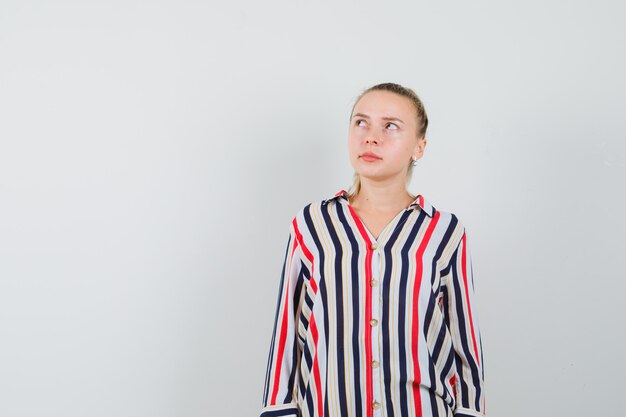 Young lady looking up in striped shirt and looking curious