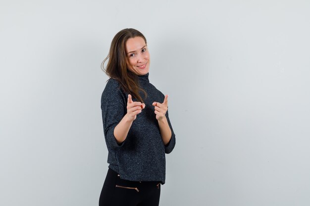 Young lady pointing at camera in shirt